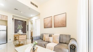 Ein modernes Wohnzimmer mit einem grauen Sofa, einem weißen Couchtisch und einem Essbereich mit Tisch und Stühlen.