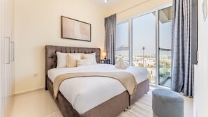 Ein modernes Schlafzimmer mit einem großen Bett, einem Nachttisch, einem Fenster mit Vorhängen und Blick auf die Stadt.