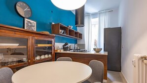 A modern kitchen with a round dining table, built-in shelves, and a large window. - Testaccio's Heart - Paulus by Rentbeat  (Roma)