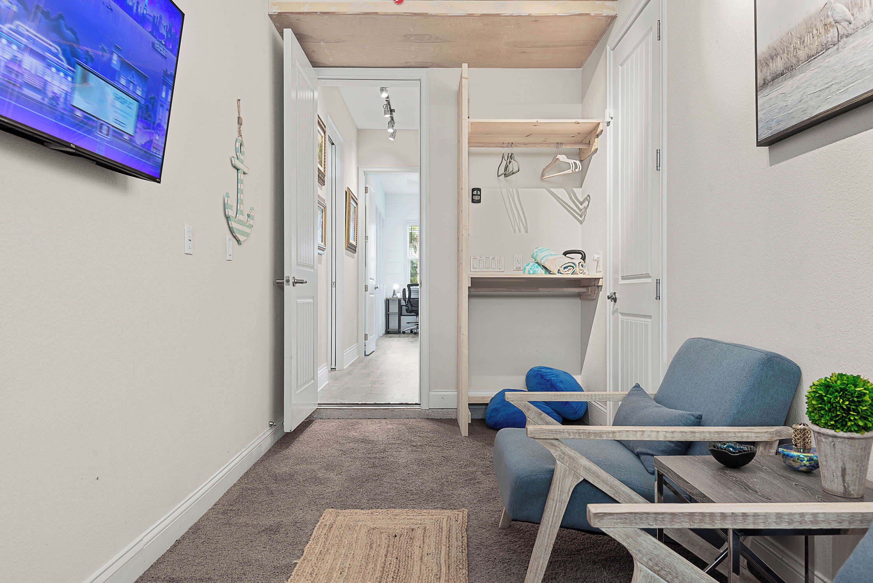 Un espace de vie compact comprenant un téléviseur, un canapé, une table basse et une petite plante.