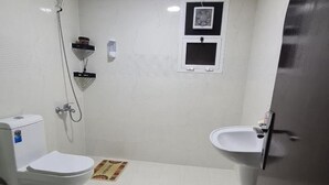 Une petite salle de bain compacte comprenant des toilettes, un bidet et un lavabo.