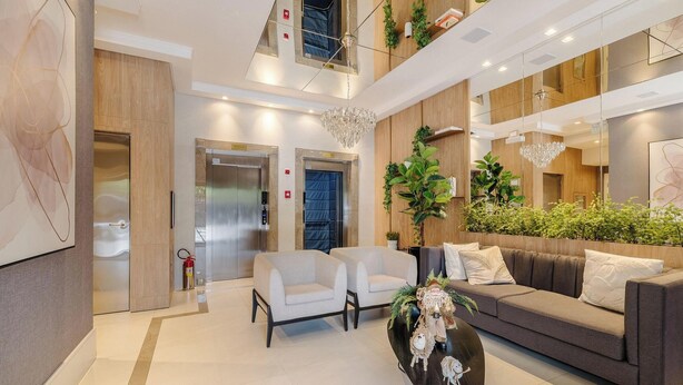 A modern lobby with a sofa, chairs, a coffee table, and a chandelier. - 2BR apt w/ BBQ 750m From Beach Rvn2003 (Itapema)