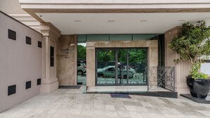 A building entrance with a tiled floor, a metal gate, and a potted plant. - 2BR apt w/ BBQ 750m From Beach Rvn2003 (Itapema)