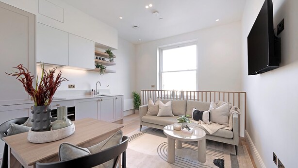 A modern living room with a sofa, coffee table, and dining area. - The Gallery Studio at Bramham Gardens (London)