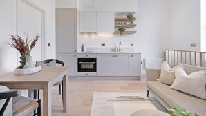 A modern kitchen with white cabinets, a built-in oven, and a countertop with a sink. - The Gallery Studio at Bramham Gardens (London)