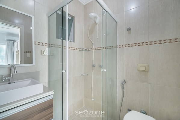 A modern bathroom with a glass-enclosed shower, a white sink, and a mirror. - 4BR Apt w/ BBQ 70m From Beach Rto0502 (Itapema)