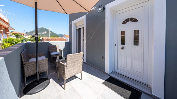 A patio with wicker furniture, a door, and a view of a mountain. - Country House 'Kate' with Mountain View, Wi-Fi and Air Conditioning (Κερκυρα)