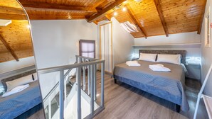 A bedroom with a wooden ceiling, a bed with a quilt, a nightstand, and a window. - Country House 'Kate' with Mountain View, Wi-Fi and Air Conditioning (Κερκυρα)