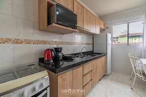 A kitchen with a stove, microwave, and sink. - 2BR Apt 260m From Canto Beach Itapema Rtl0302 (Itapema)