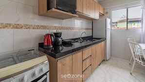 Cozinha com fogão, micro-ondas e pia.