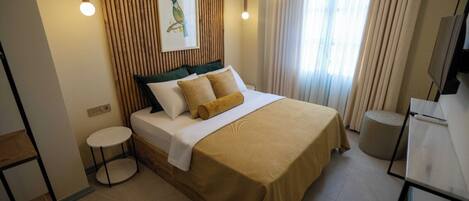 A neatly arranged hotel room with a bed, bedside table, and a small round table.