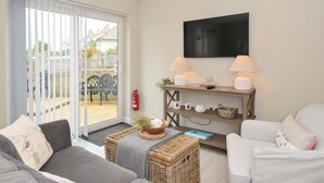 Ein Wohnzimmer mit einer Couch, einem Sessel und einem kleinen Tisch mit Lampen und Dekoration.