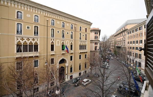 A multi-story building with a symmetrical facade, large windows, and a central entrance with an archway. - Rental in Rome Dolce Vita Suite (Rome)