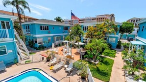 A pool area with lounge chairs and a flag.