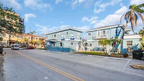 A two-story building with 'Coral' signage, a parking lot, and palm trees.