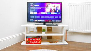 A flat-screen TV on a white entertainment unit with a game box labeled "Ludo Roulette" underneath. - 2BR Near Crouch Hill, Camden & Emirates Stadium (London)