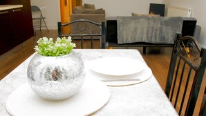 A dining table with a decorative vase and plates, a chair, and a sofa in the background. - 2BR Near Crouch Hill, Camden & Emirates Stadium (London)