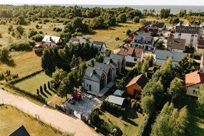 A residential area with houses, a fenced property, and a body of water in the background.