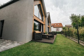 A modern house with a patio, outdoor furniture, and a well-maintained lawn. - Holiday home near the sea, air conditioning (Sianozety)