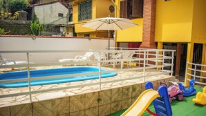 A children's play area with a pool, slides, and a table with chairs. - POUSADA KLEIN (Nova Friburgo)