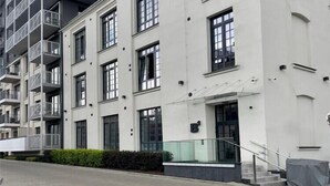 Ein modernes Mehrfamilienhaus mit Balkonen, großen Fenstern und einem überdachten Eingang.