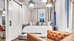 Une chambre moderne avec un lit, un canapé en cuir et une fenêtre avec des rideaux.