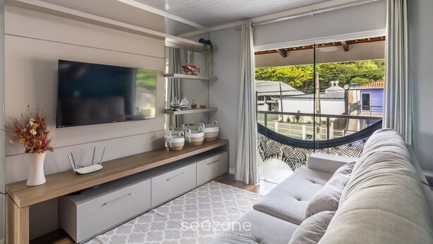 A modern living room with a flat-screen TV, wooden console, and a hammock. - Apt w/ Balcony, 3 Bedrooms Close to Beach Rsu3842 (Penha)