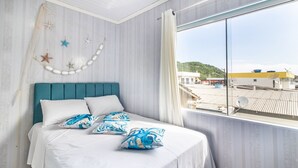 A bedroom with a teal headboard, white bedding, and decorative starfish and seashells on the wall. - Apt w/ Balcony, 3 Bedrooms Close to Beach Rsu3842 (Penha)