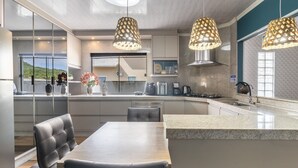 A modern kitchen with a central island, pendant lights, and a view of the outdoors. - Apt w/ Balcony, 3 Bedrooms Close to Beach Rsu3842 (Penha)