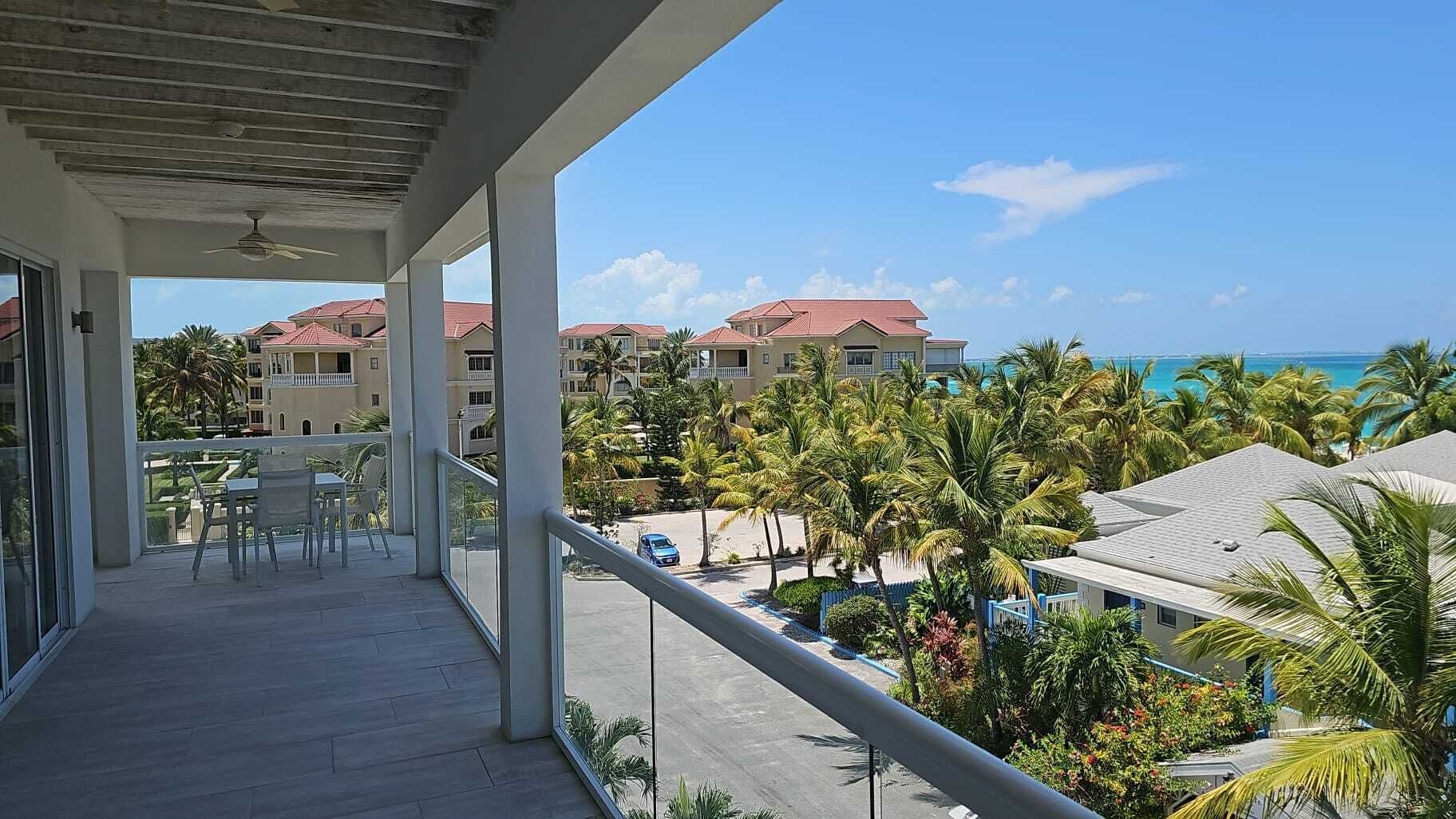 Un balcon donnant sur une zone touristique, avec plusieurs bâtiments et une plage.