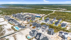 Zona residencial à beira-mar com casas modernas, piscina e praia.