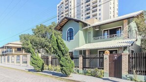 Un edificio residencial con fachada verde, una ventana visible y un acceso con portón.