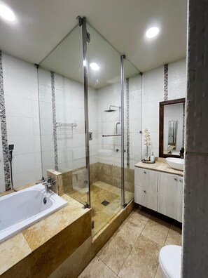Een douche, handdoeken, zeep, toiletpapier