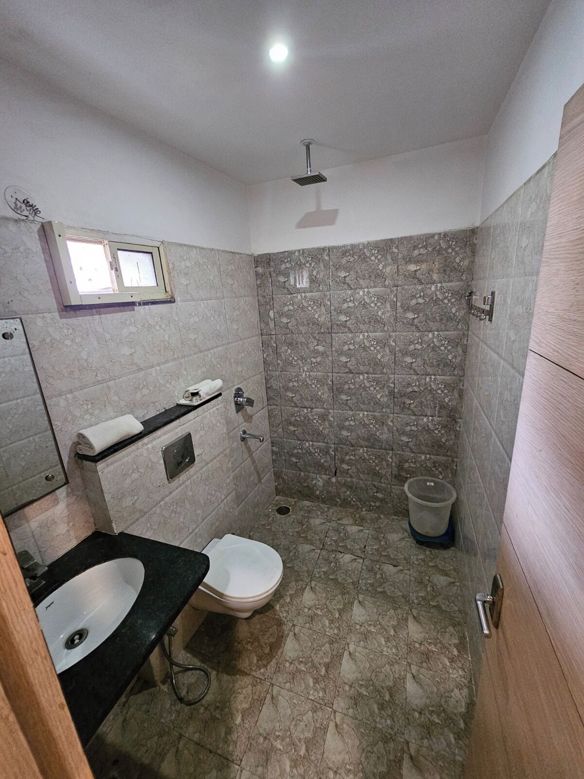 Une salle de bain comprenant des toilettes, un lavabo et un espace douche.