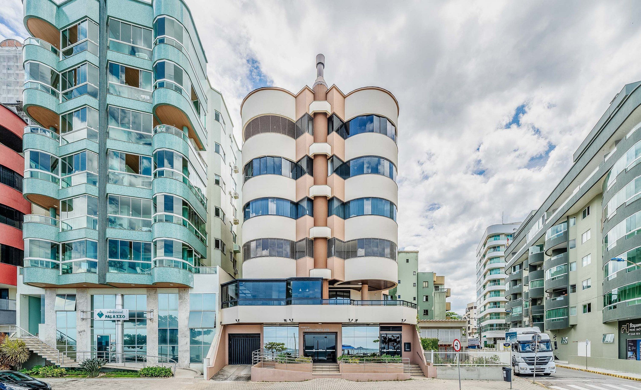 A multi-story building with a central atrium, large windows, and a sign indicating it is a residential area.