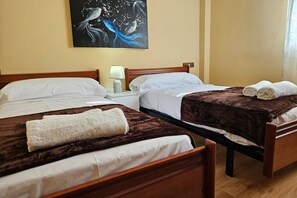 Ein Hotelzimmer mit zwei Betten, einem Nachttisch mit Lampe und einem Bild an der Wand.