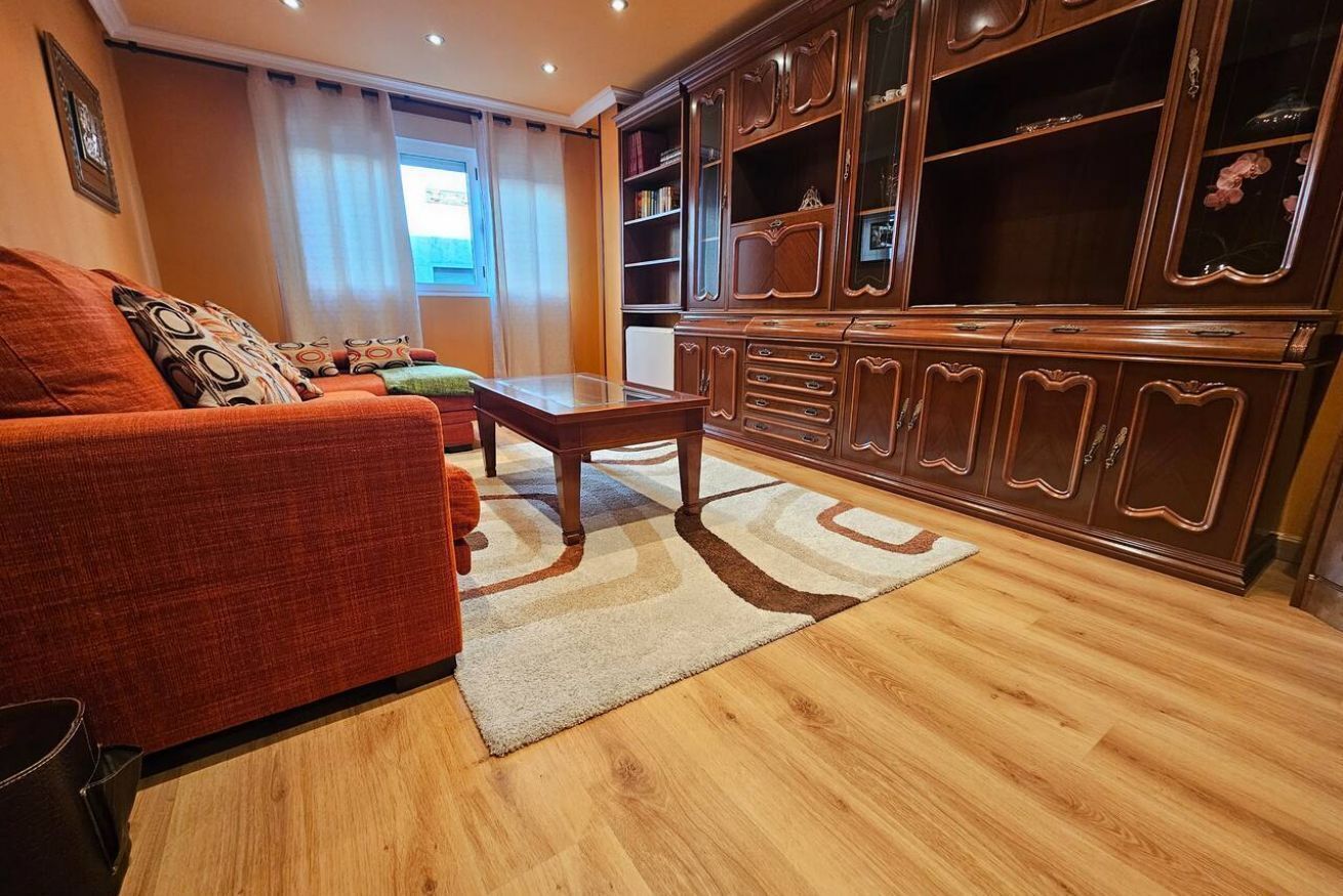 A living room with a sofa, coffee table, and wooden cabinet.