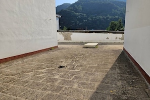 A rooftop with a view of a mountainous landscape.