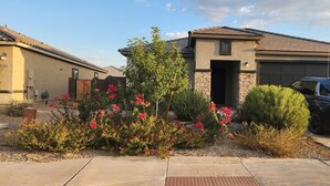 A residential house with a garage, a driveway, and a parked SUV. - Beautiful and Comfy 4-bedroom house with AC in Maricopa (Maricopa)