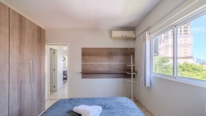 A modern bathroom with a shower, a towel on the floor, and a window with a view of buildings. - Charming Apt 550m From Pereque Beach - Rne0301 (Porto Belo)