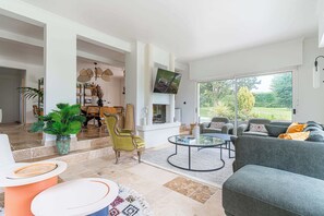 Televisie, een open haard, boeken en een kantoor