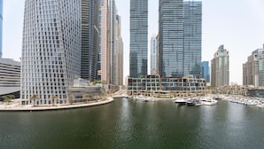 Un port de plaisance où sont amarrés des bateaux, entouré d’immeubles modernes de grande hauteur.