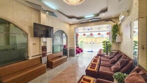 A spacious lobby with a modern design, featuring a large seating area with sofas and a TV mounted on the wall. - FOUR SEASONS HOTEL NHA TRANG (Nha Trang)