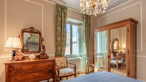 Ein Schlafzimmer mit Bett, Kommode, Stuhl und Kleiderschrank.