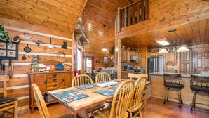 L’intérieur d’une cabane en bois comprend un coin repas, une cuisine et une chambre à coucher située en mezzanine.