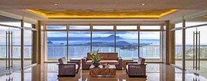 Amplia sala de estar con un ventanal que ofrece vistas al mar y a las montañas.
