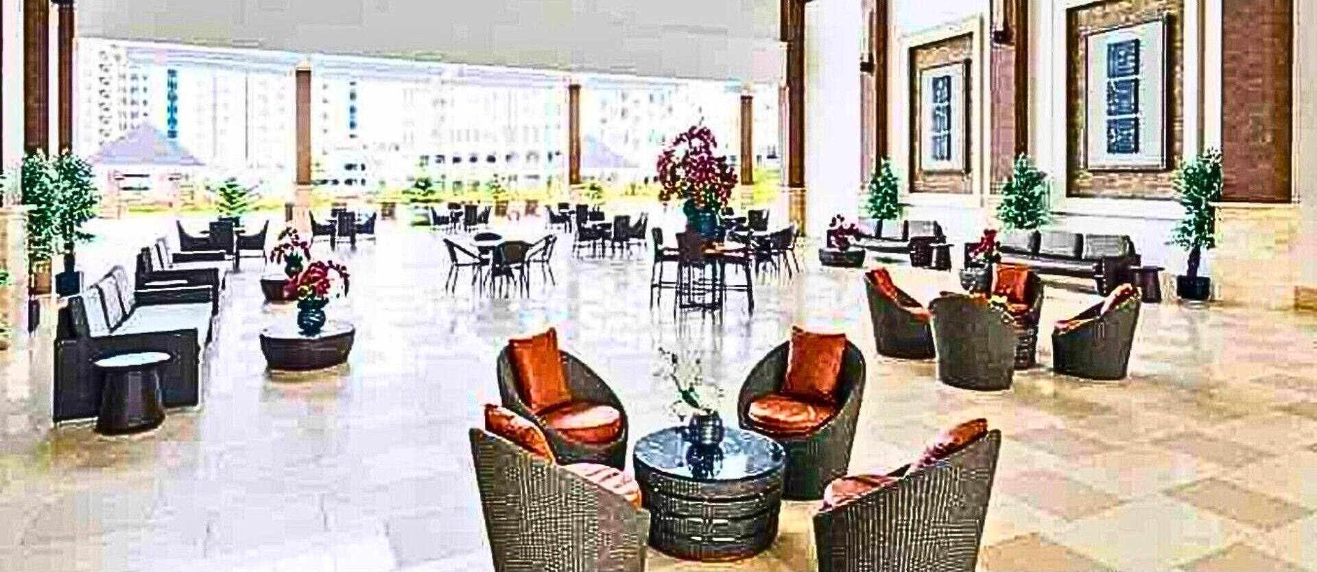 Un hall amplio con varias zonas de estar, incluyendo sofás y sillones, dispuestos alrededor de una mesa de centro.