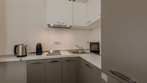 A modern kitchen with stainless steel appliances, a sink, and cabinets. - Priocca 028 by Wonderful Italy (Torino)