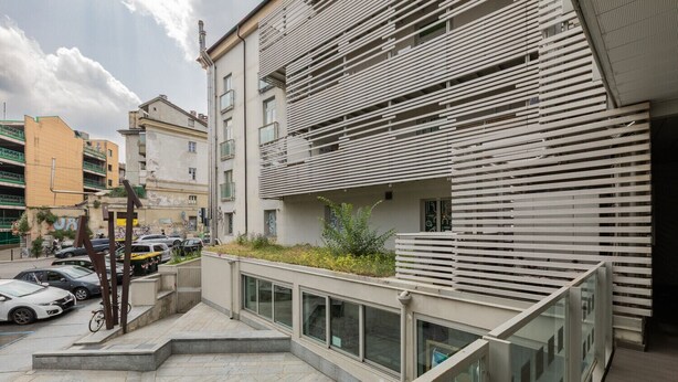 A modern building with a flat roof, large windows, and a balcony with metal railings. - Priocca 028 by Wonderful Italy (Torino)