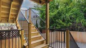 Une terrasse en bois avec un escalier menant à un niveau supérieur.
